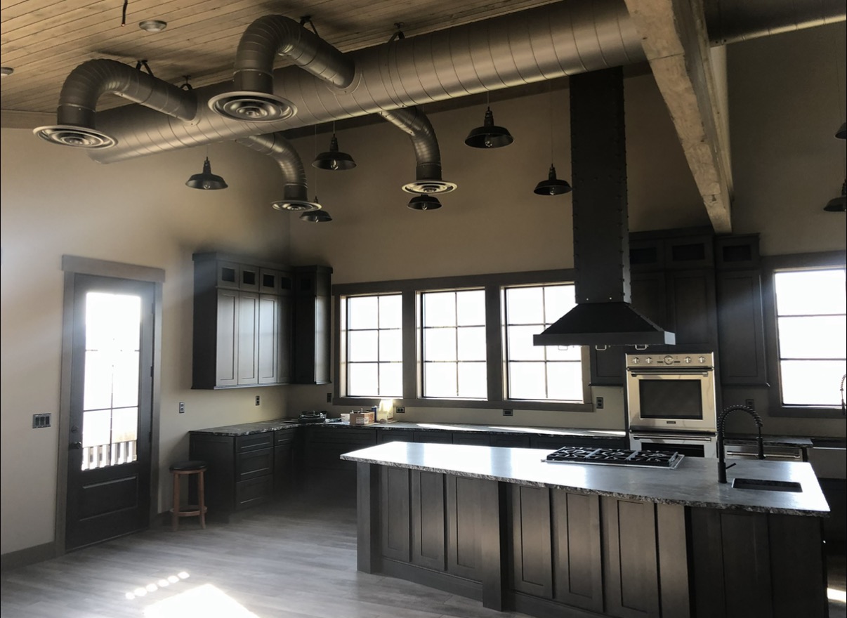 Custom exposed ductwork in modern kitchen with wood ceiling